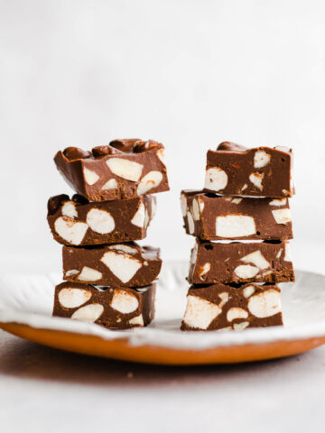 Fudge with marshmallows stacked on a plate.
