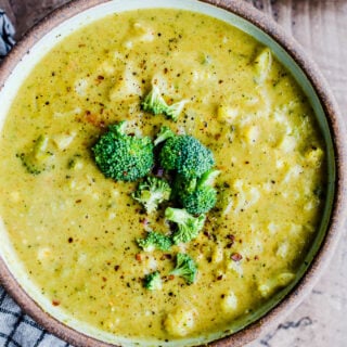 Curried broccoli cauliflower soup in a rustic bowl.