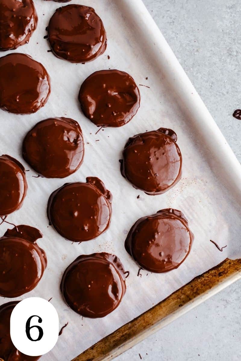 Chocolate coated cookies on a baking sheet. 