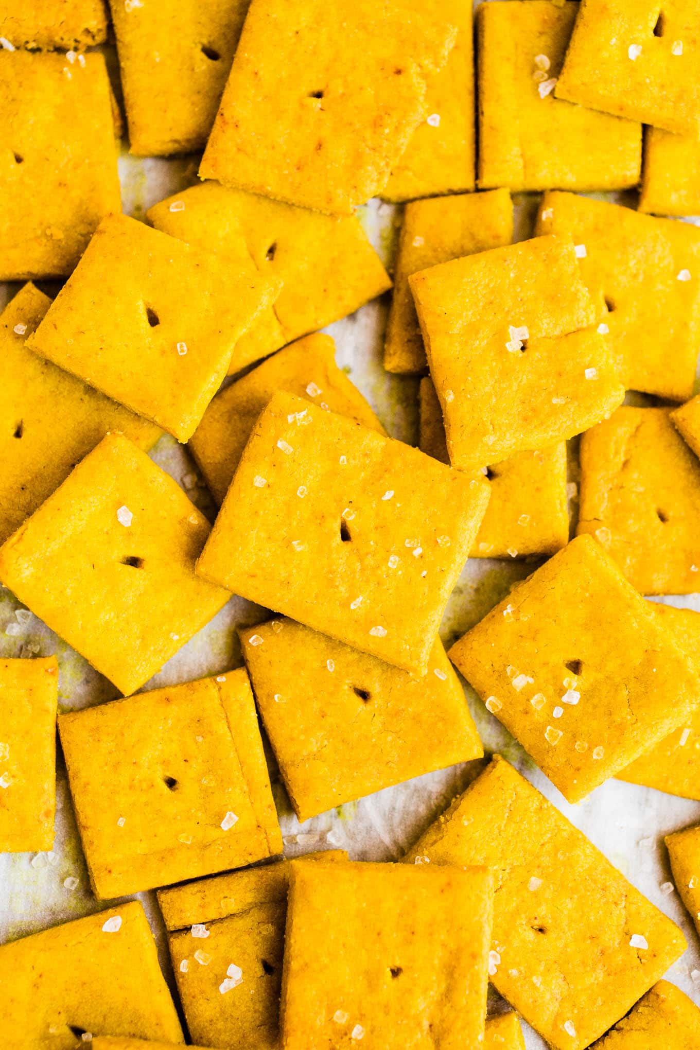 Cheese crackers with sea salt on parchment paper.