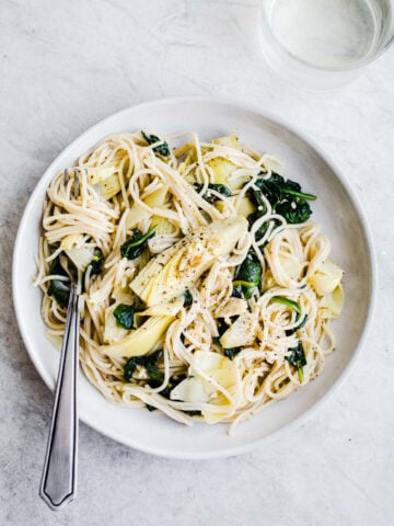 spinach and artichokes with pasta on plate
