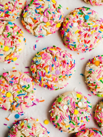 Funfetti cookies with rainbow sprinkles on parchment.