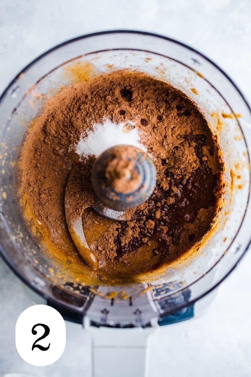 Almond butter and cocoa powder in a food processor.