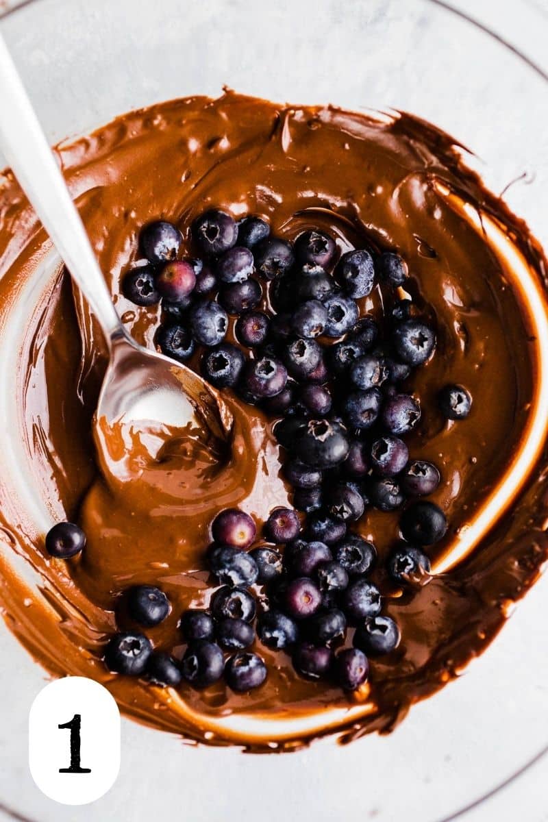 Melted chocolate in a bowl with blueberries.