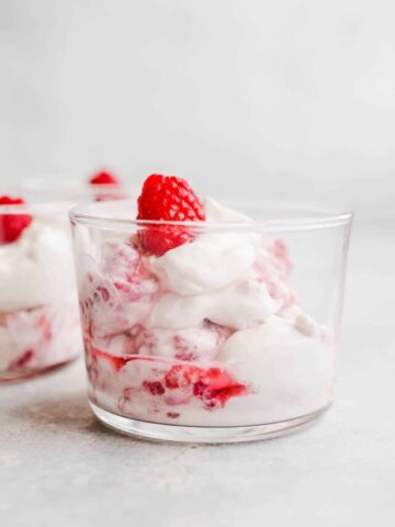 Whipped cream and raspberries in a glass.