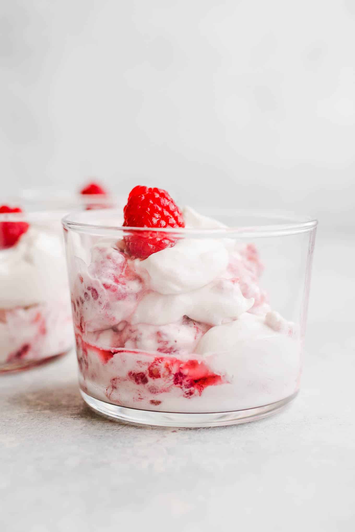 Whipped cream and raspberries in a glass.