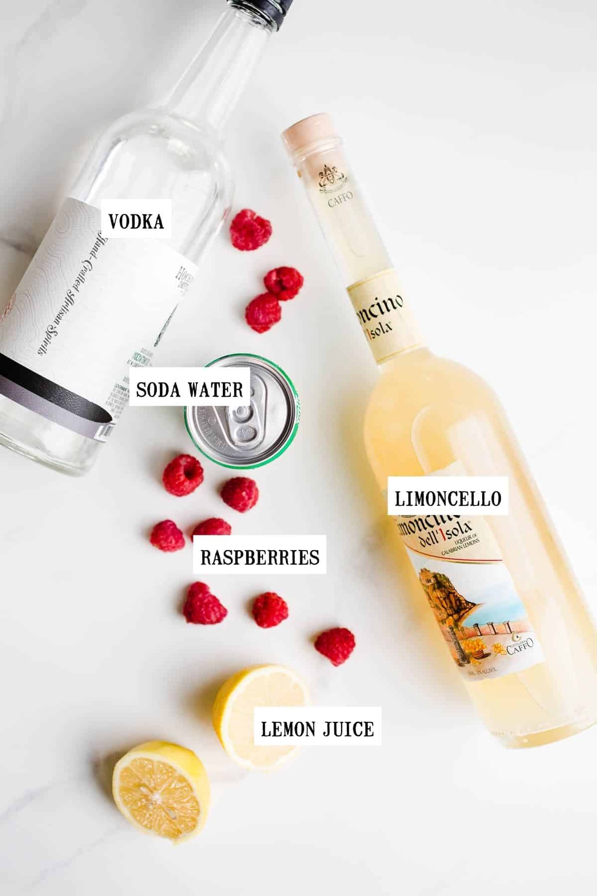 Ingredients for a limoncello cocktail on a white surface. 