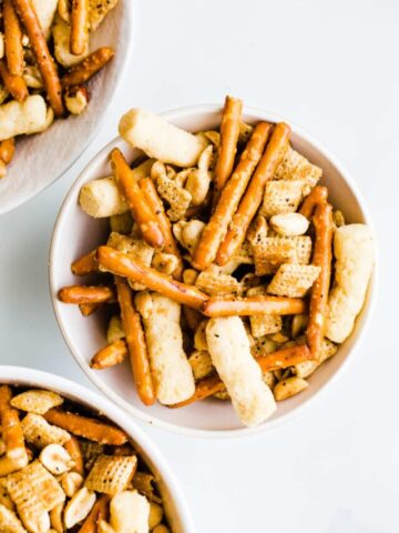 Snack mix in white bowls.
