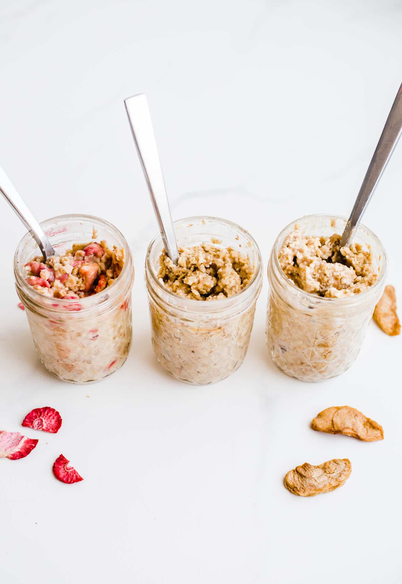 Three mason jars filled with cooked oatmeal.