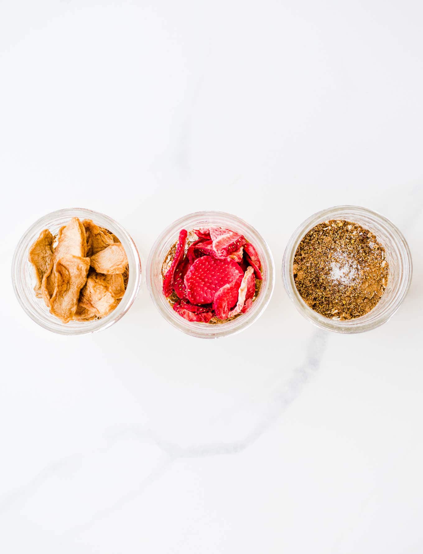Flavored instant oatmeal with freeze-dried fruit in three mason jars.