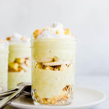 gelbes dessert mit vanillekeksen und bananenscheiben in einem glas.