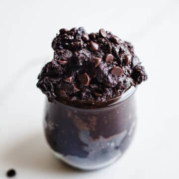 Brownie batter with chocolate chips in a small glass jar.