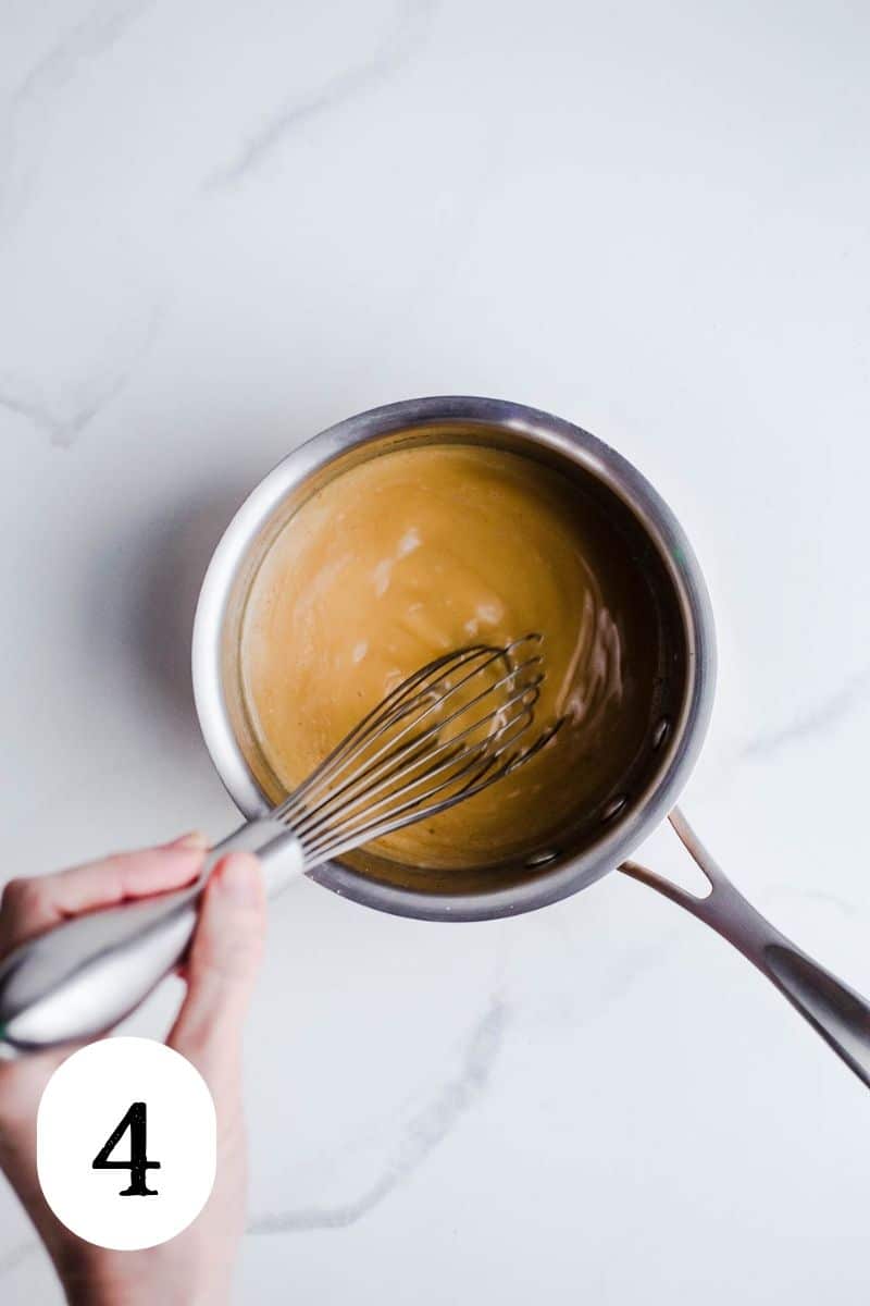 A vanilla sauce being whisked in a small saucepan.