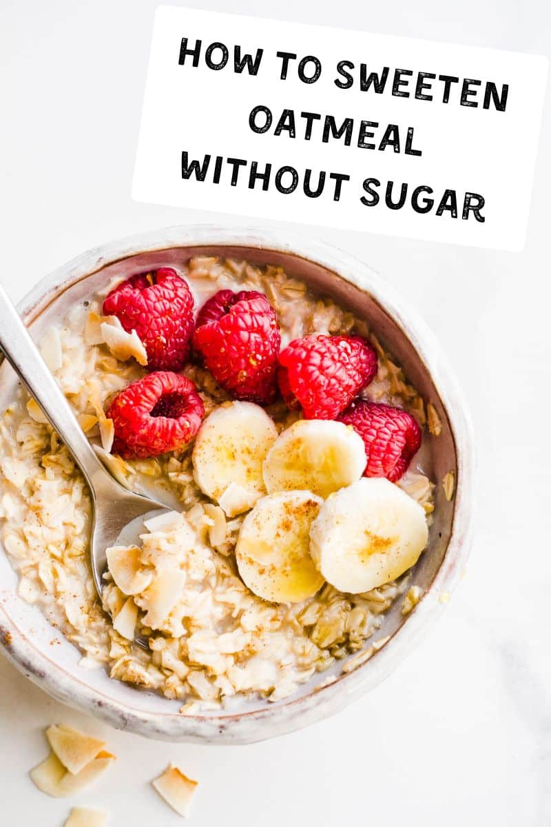 A bowl of oatmeal with bananas, raspberries, and coconut flakes on top. 