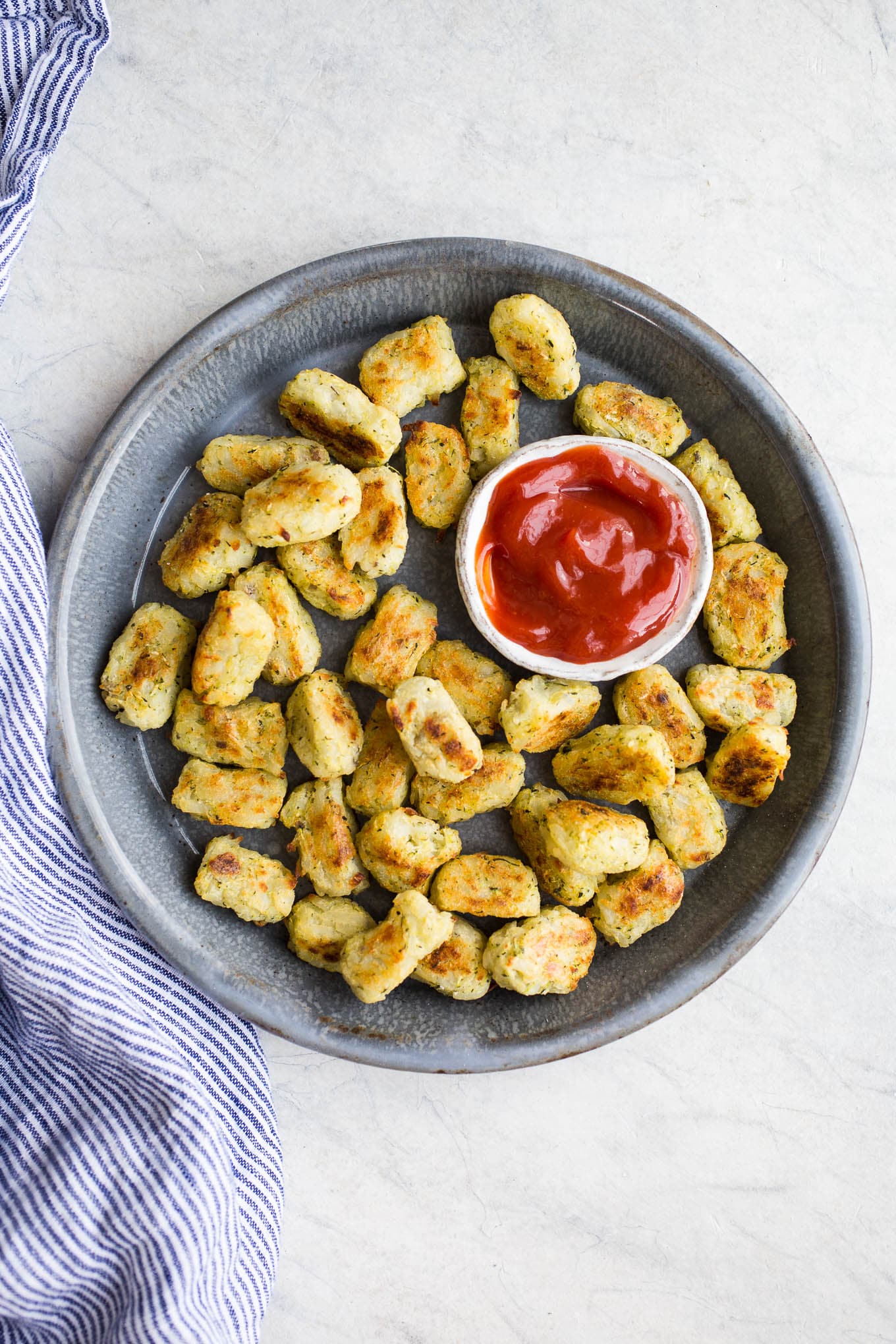 Veggie tots on a blue platter.