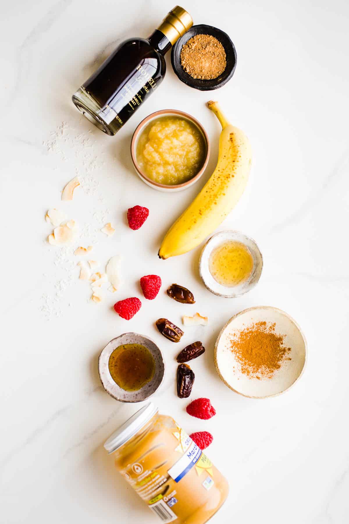 Fruit, syrups, and spices laid out on a marble surface.