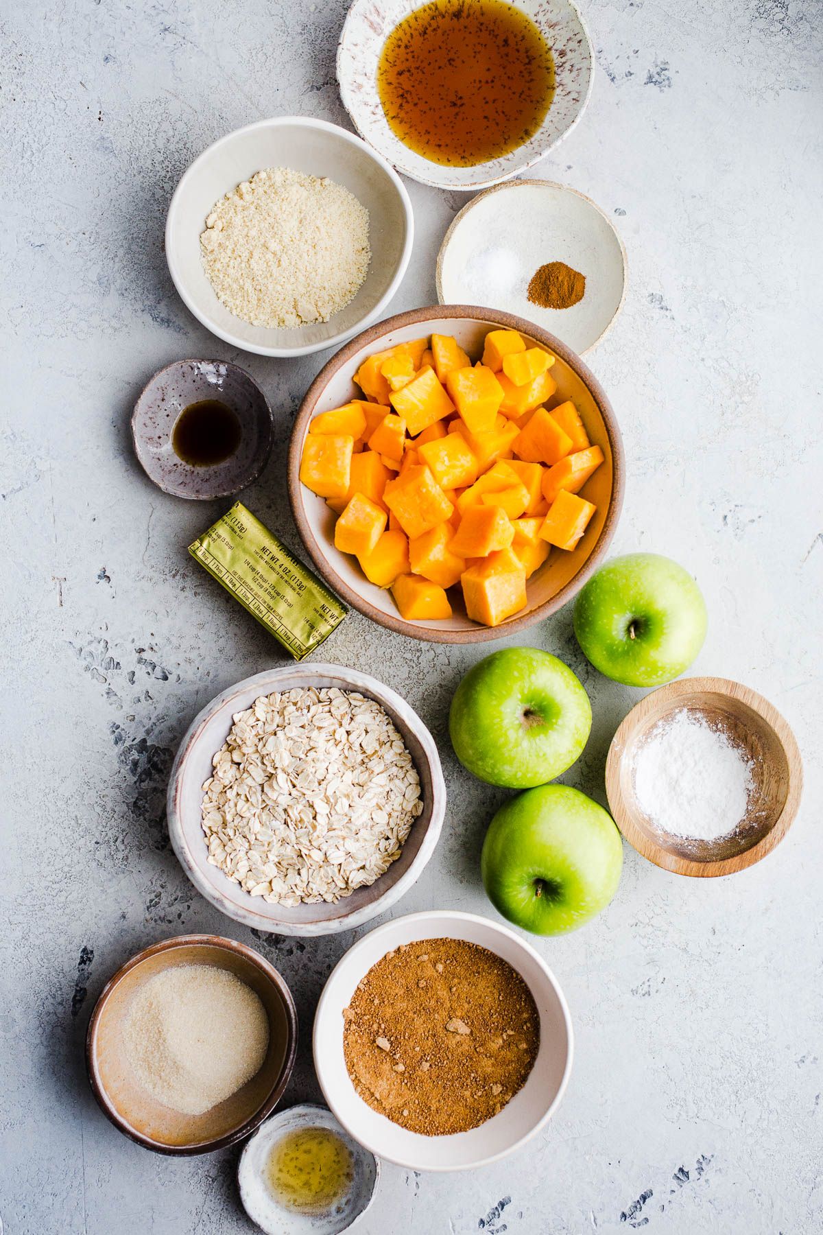 Ingredients for baking set out in bowls on a gray surface.