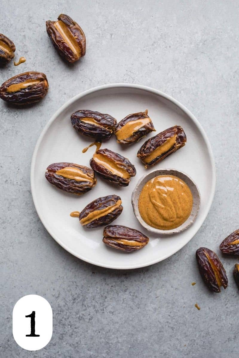 Dates stuffed with almond butter on a gray plate.