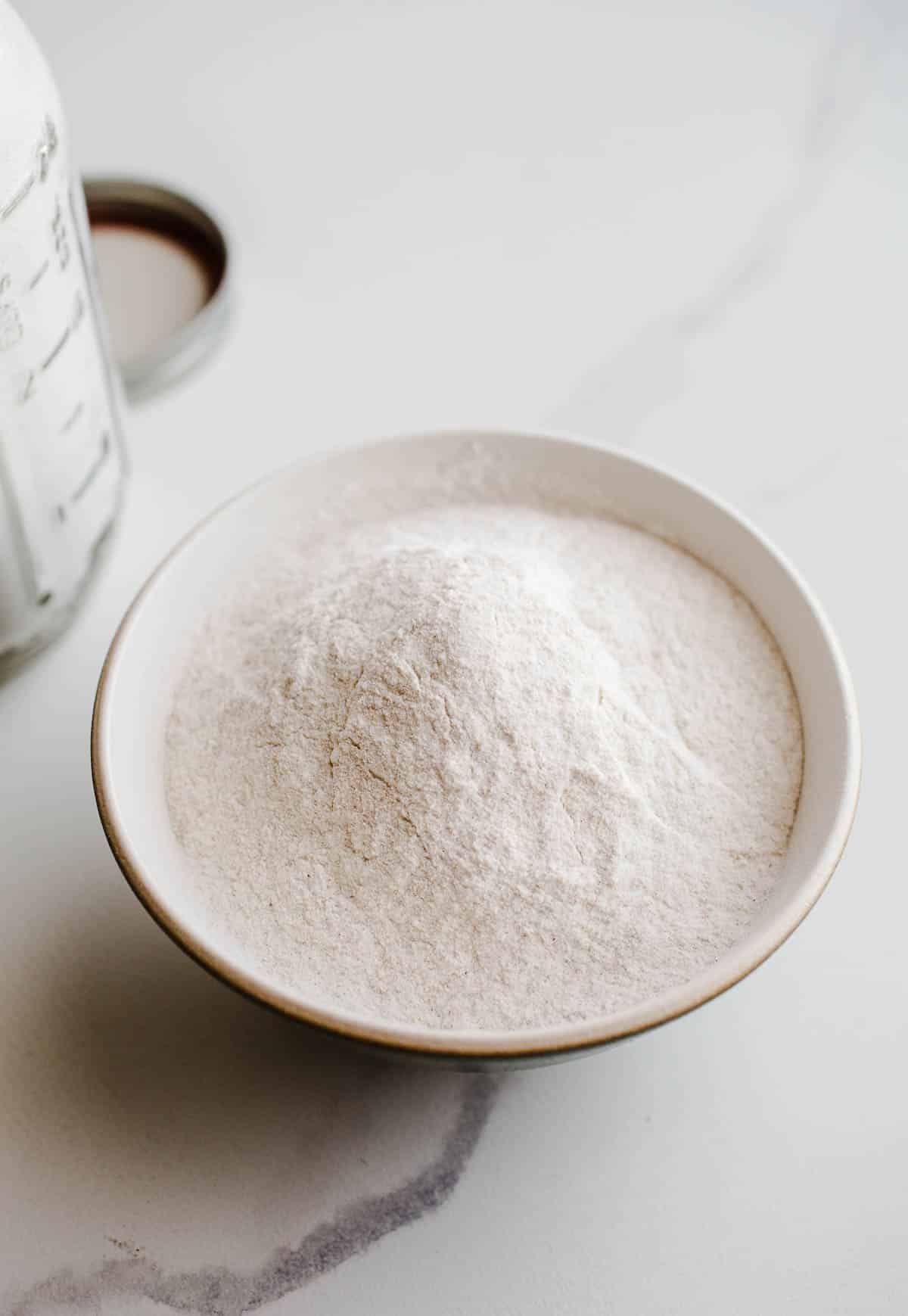 Buckwheat flour in a bowl on a marble surface. 