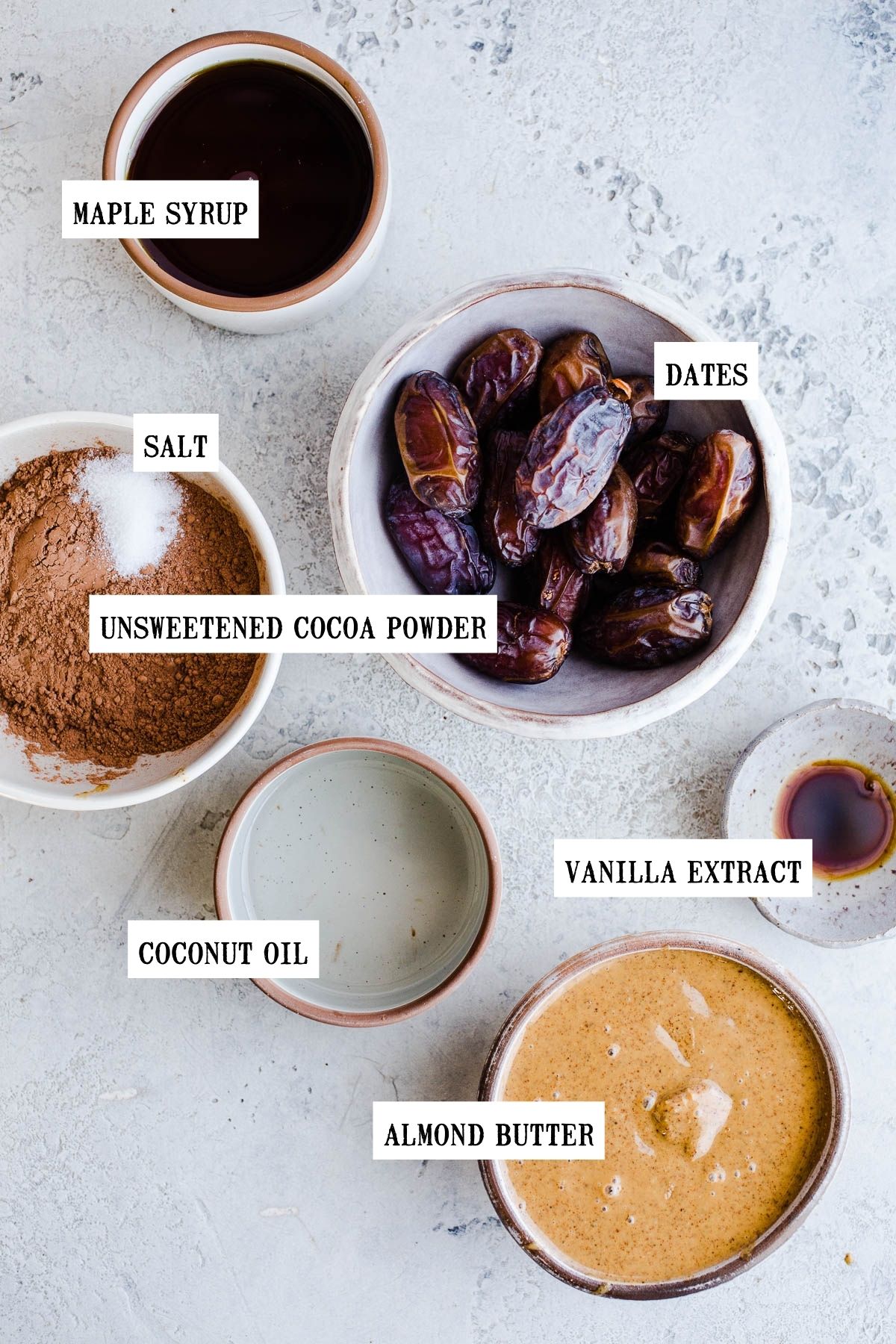 Ingredients to make chocolate covered dates separated into different size bowls.