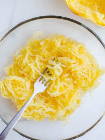 Yellow veggie noodles in a glass bowl.