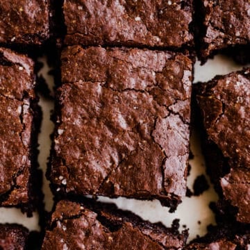 Freshly cut chocolate brownies on white parchment paper.