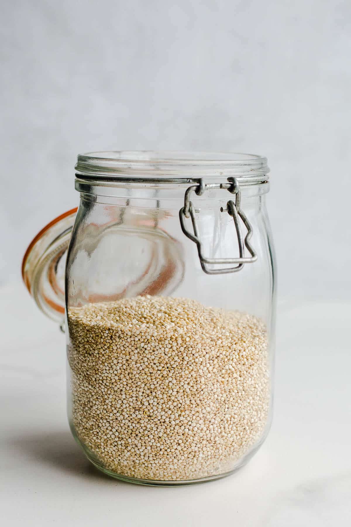 A glass jar with a lid with seeds inside.