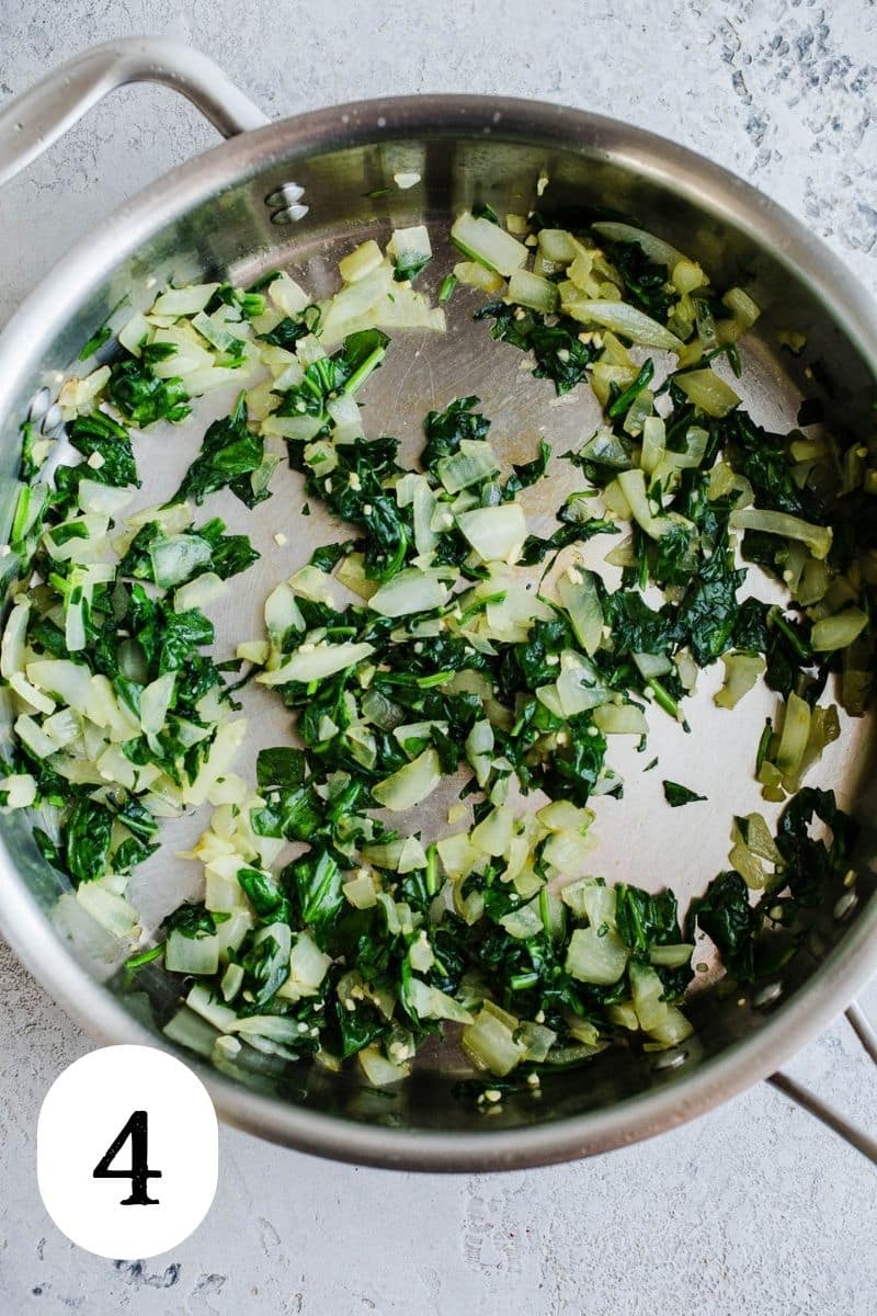 Wilted greens and onions in a large skillet.