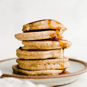 A stack of pancakes on a rustic plate.