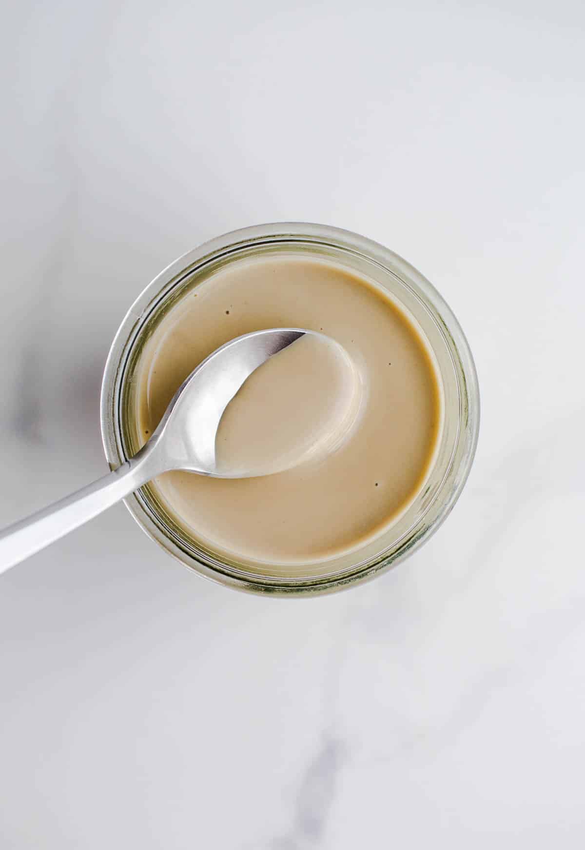 A spoon scooping out sesame seed butter.