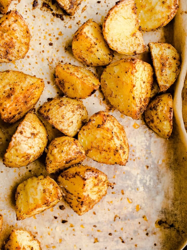 Seasoned potato chunks on a sheet pan.