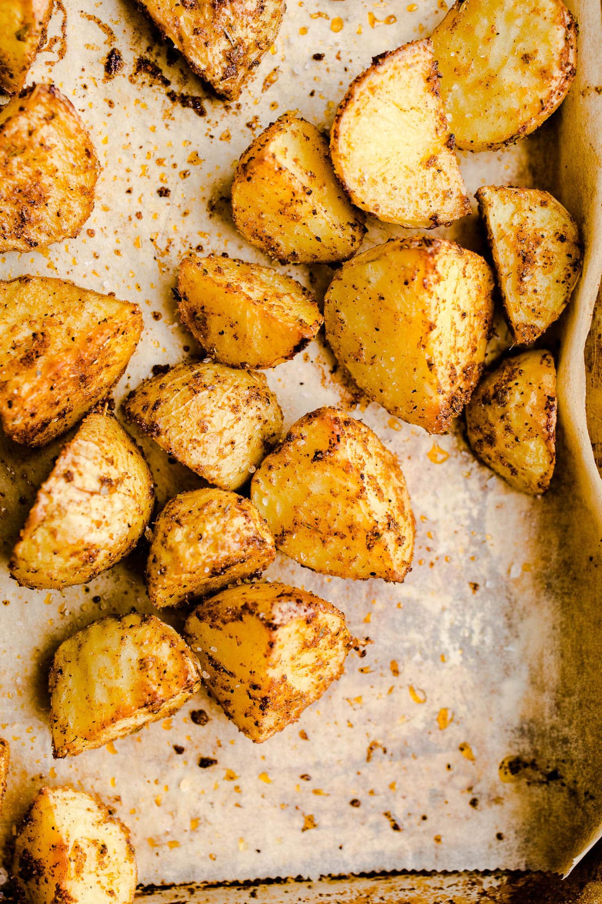 Seasoned potato chunks on a sheet pan.