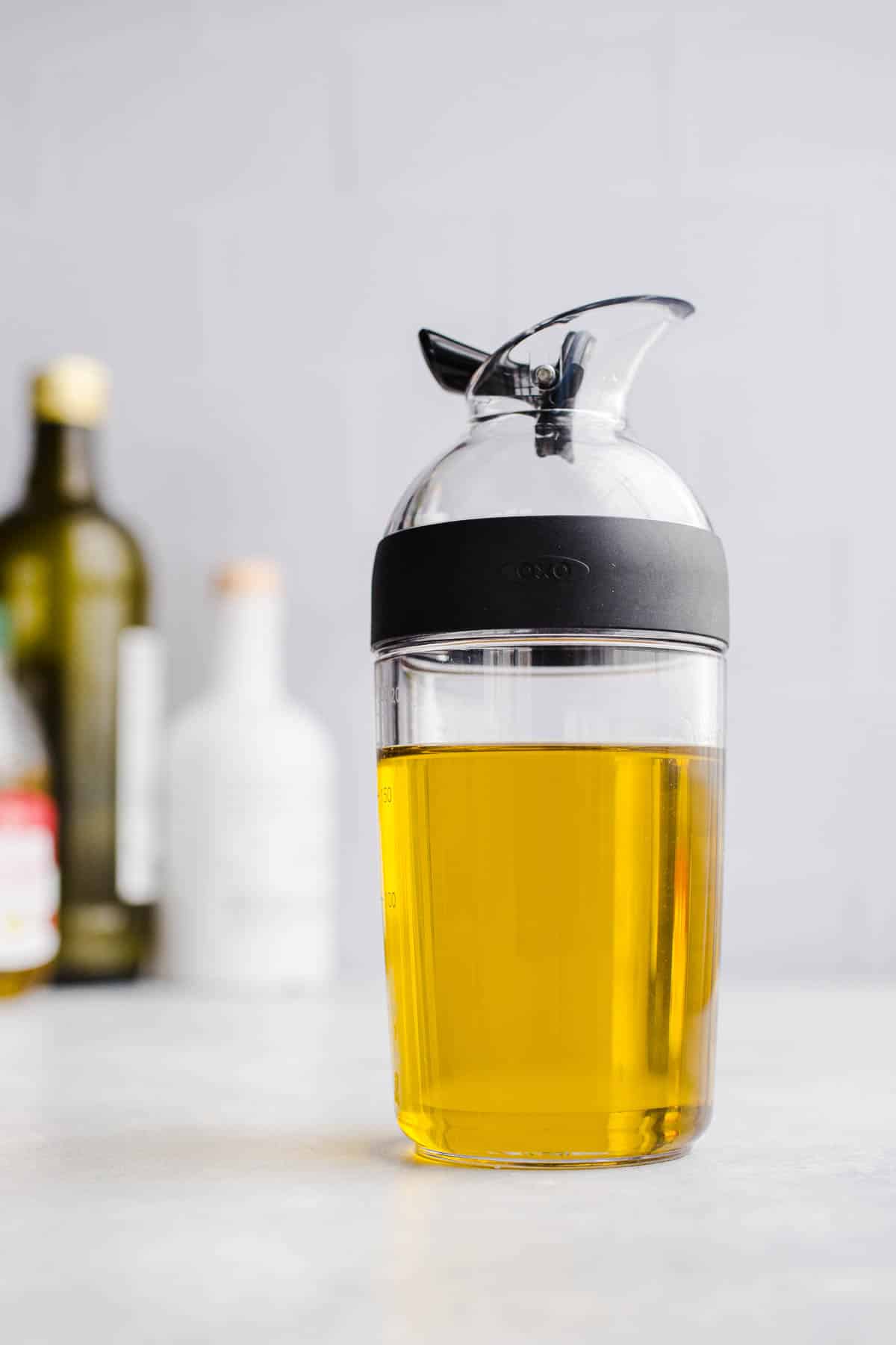 A bottle with a spout filled with oil.