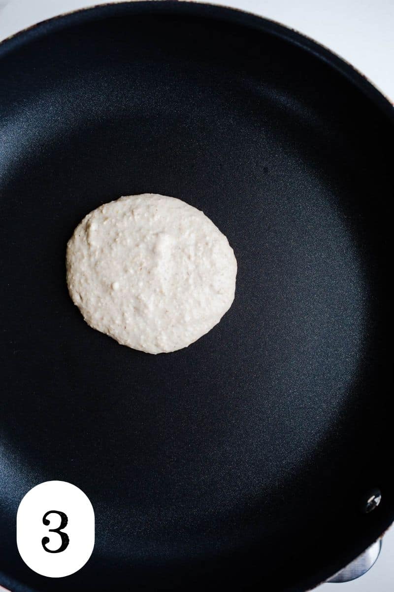 A nonstick pan with a raw pancake.