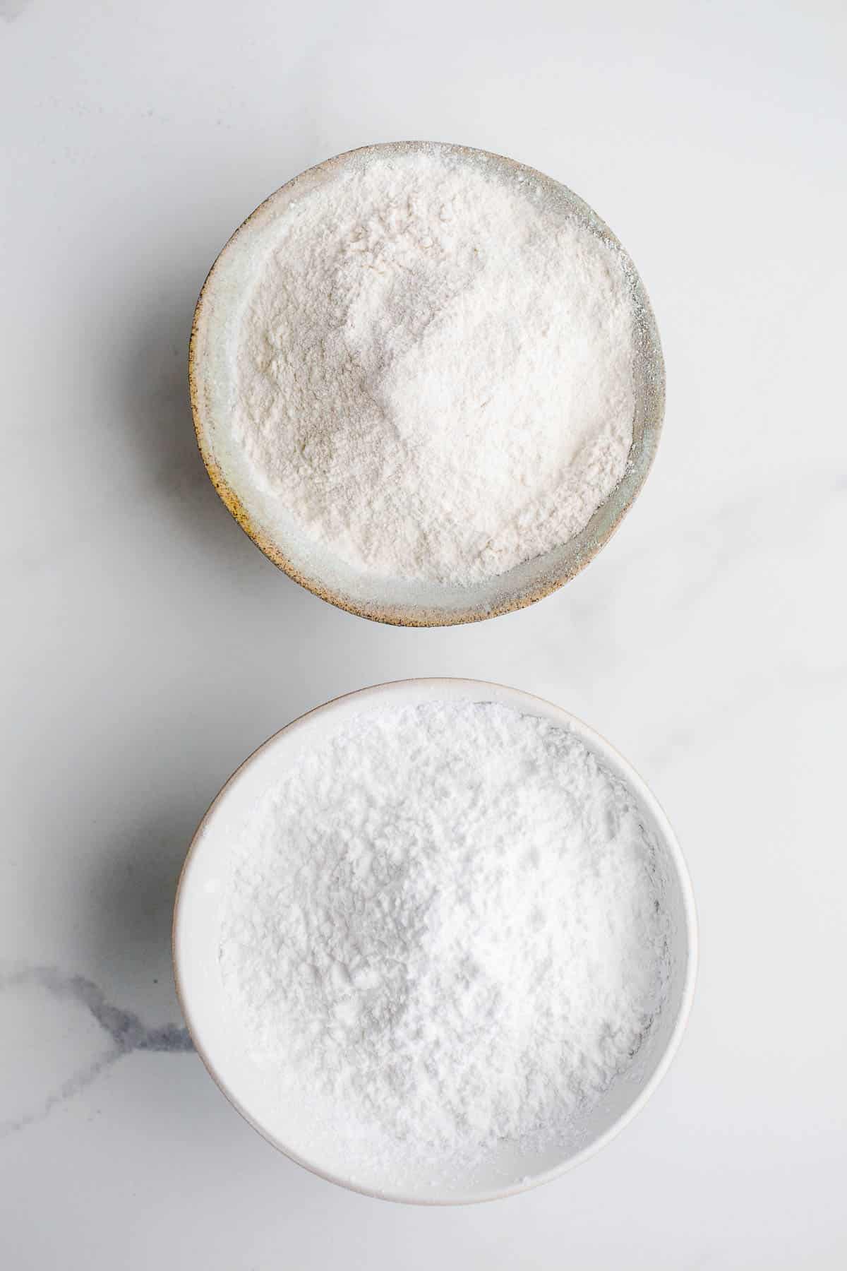 Two small bowls with white powdery flour.