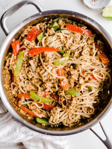 Chicken stir fry with noodles in a large pan.