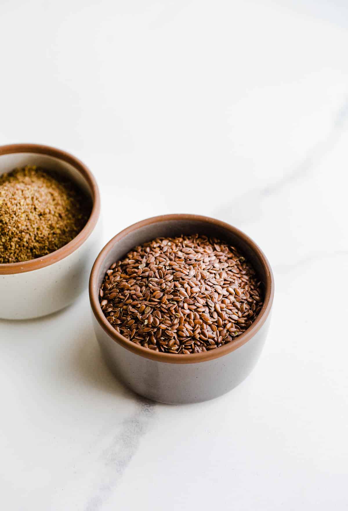 Whole and ground gluten-free seeds in two small bowls.