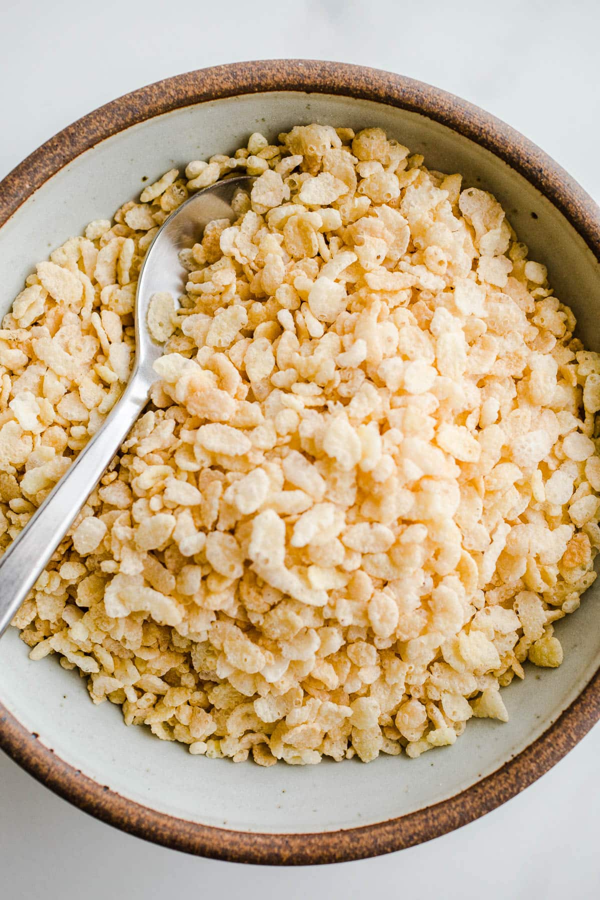 A big bowl of cereal with a spoon sticking out.