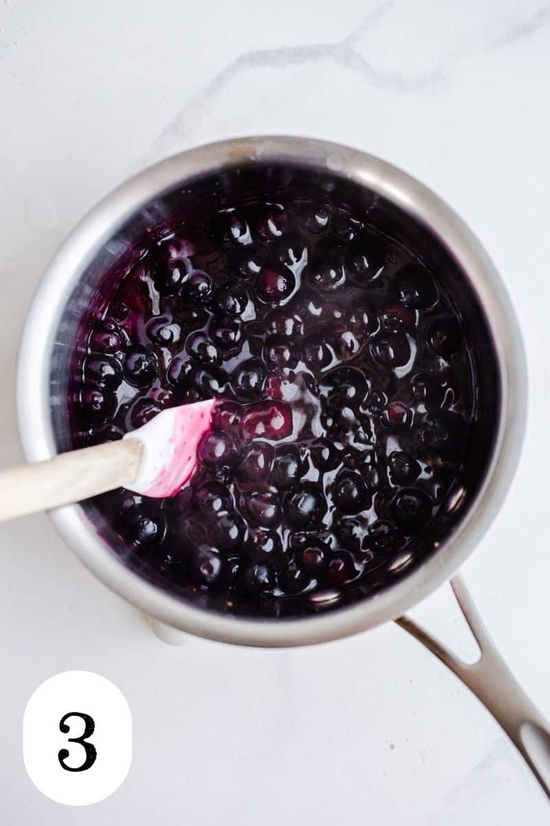 Blueberries and sugar syrup in a saucepan.