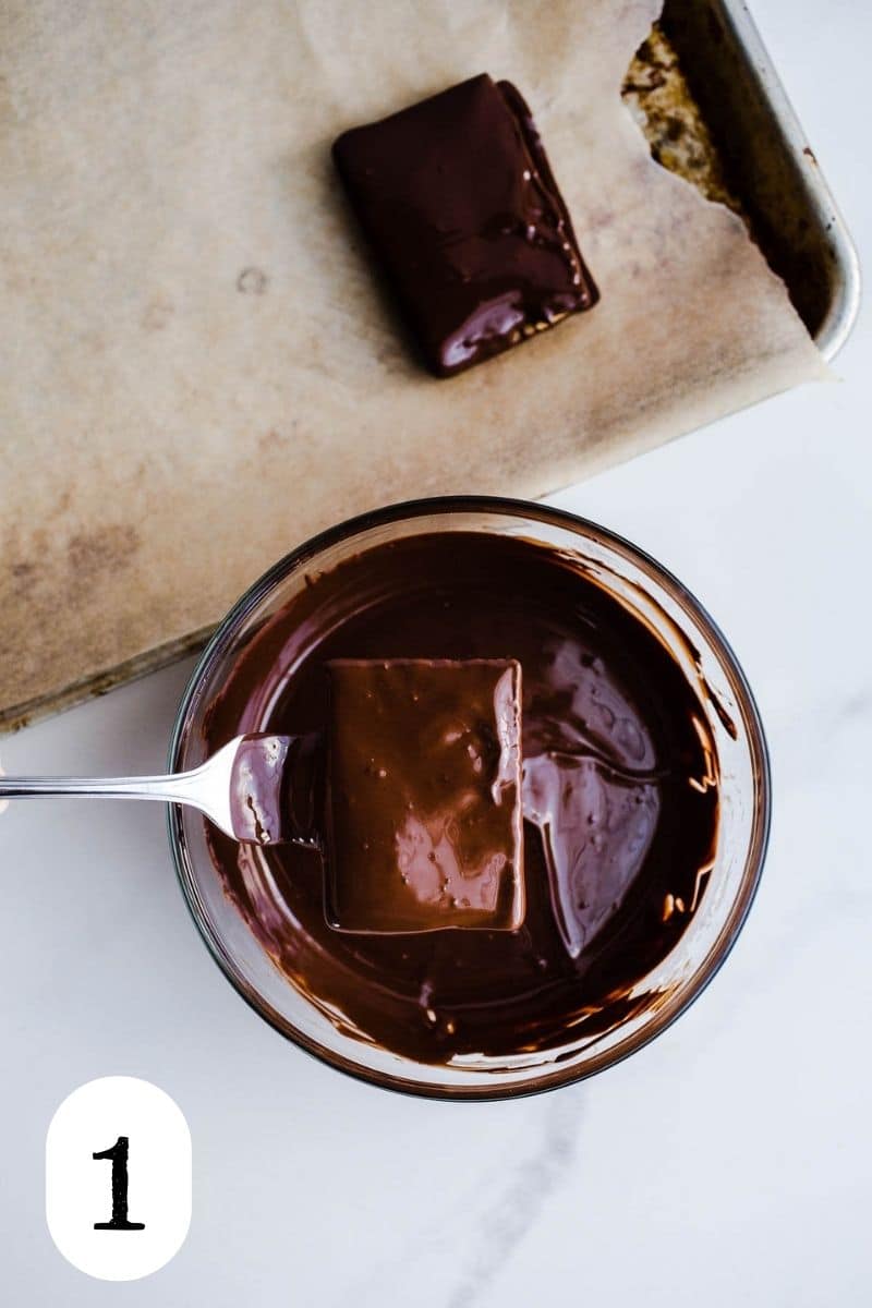 A cookie dipped in a bowl of melted chocolate.