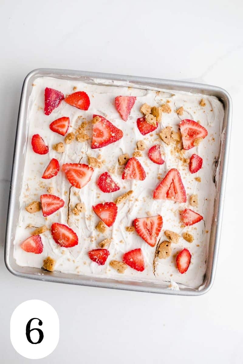 A cake with strawberries and graham cracker crumbs.