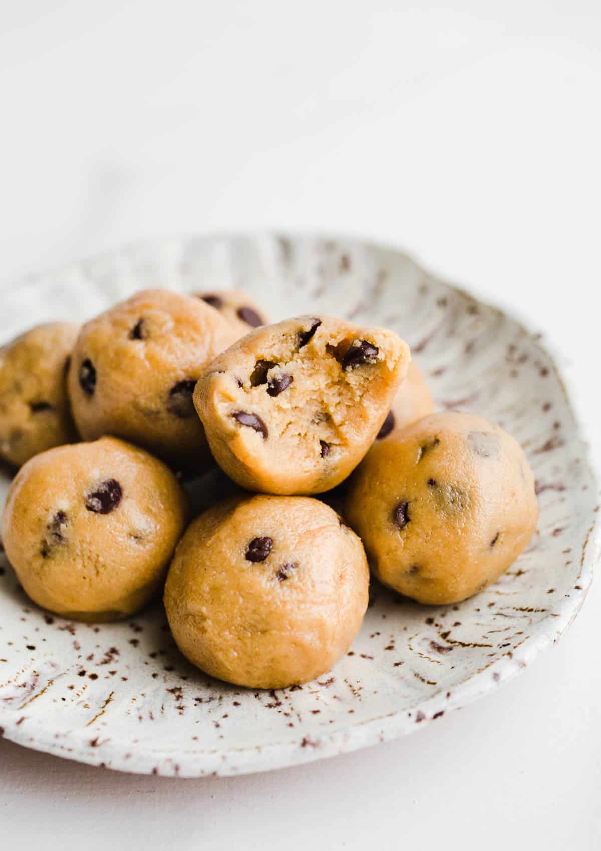 Chocolate chip bites on a white speckled plate.