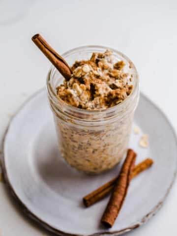 Oats and cinnamon stick in a jar.