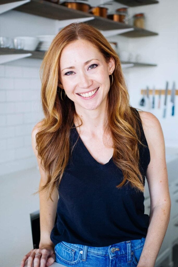 The founder of Salted Plains blog standing in a white kitchen.