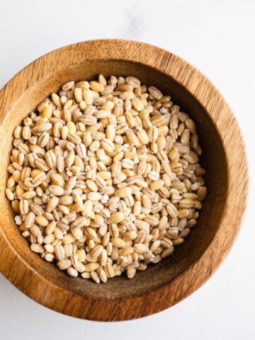 A small wooden bowl filled with barley.
