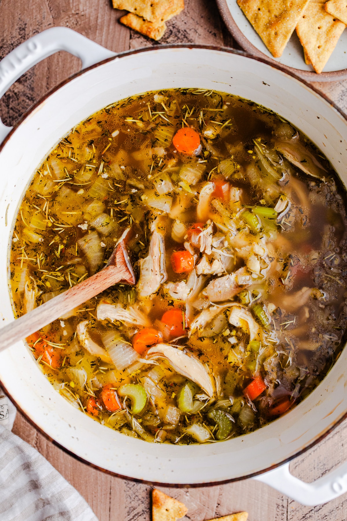 A pot of chicken soup with vegetables. 