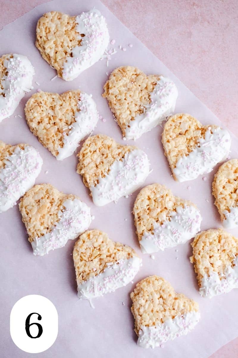 White chocolate dipped heart treats on parchment paper.