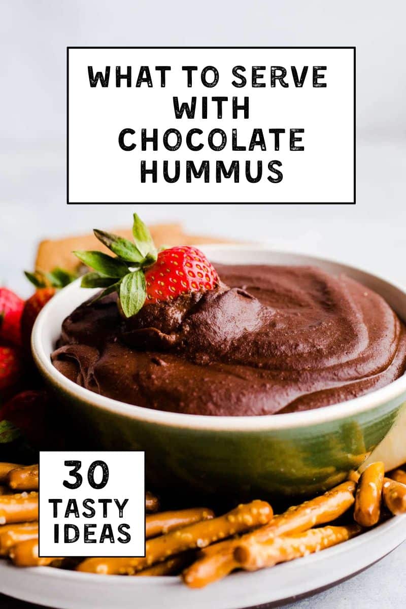 A bowl of chocolate hummus with a strawberry dipped in it.