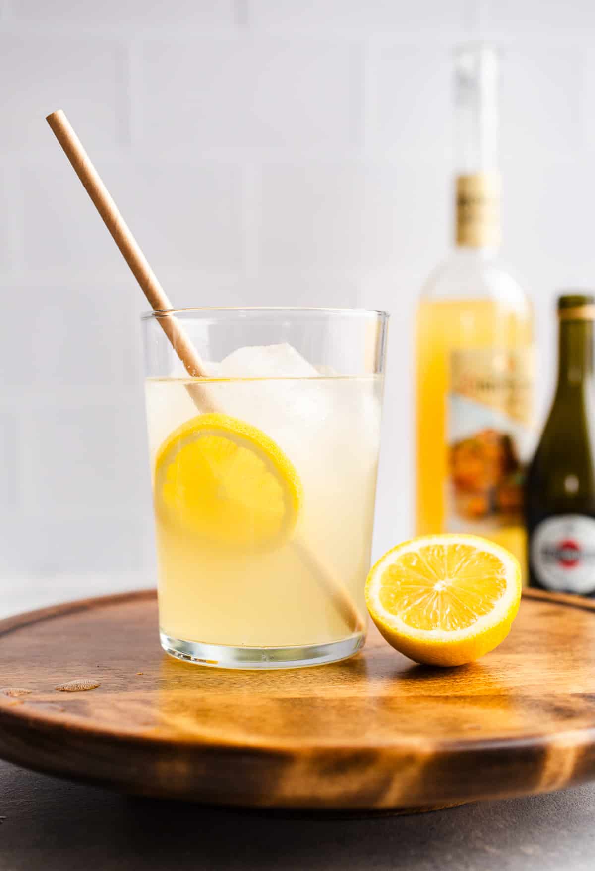 A cocktail glass filled with lemon slices and Prosecco.