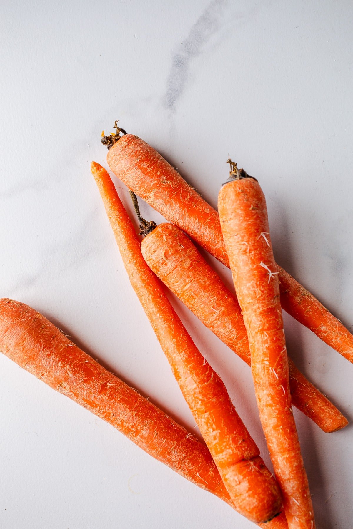 Raw carrots on a marble surface. 